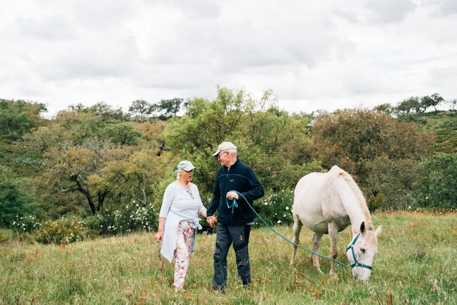 Ein Paar Hand in Hand mit einem Pferd im Alentejo